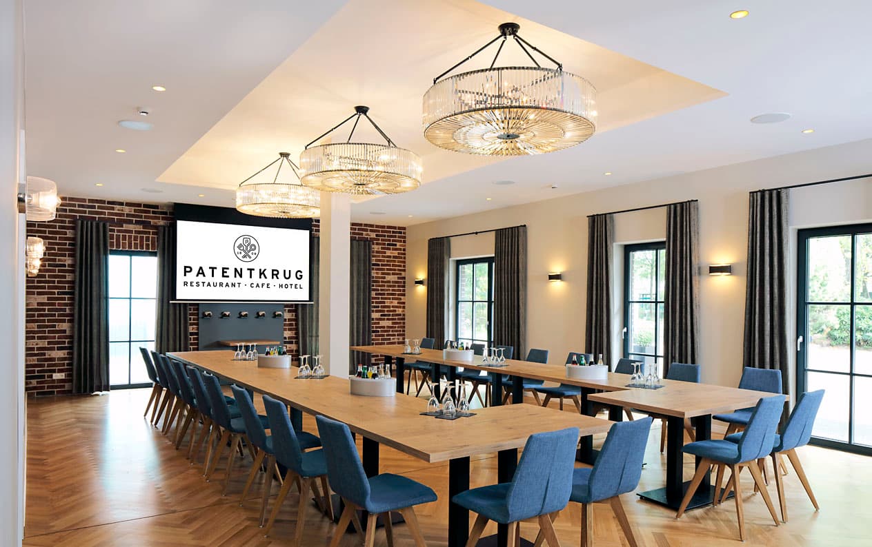 Tagungsraum im Patentkrug mit langer Tafel, Leinwand und Kristallleuchtern