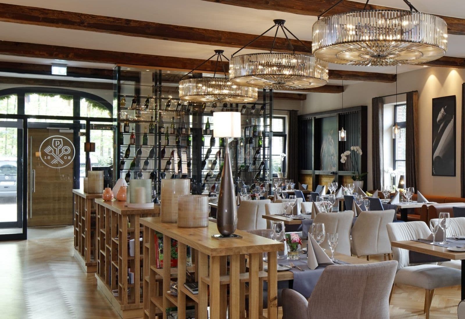 Restaurant im Patentkrug mit Kristallleuchtern, Holzbalken, Weinregal und gedeckten Tischen